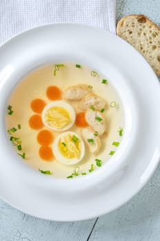 Portion of clear chicken broth in white plate