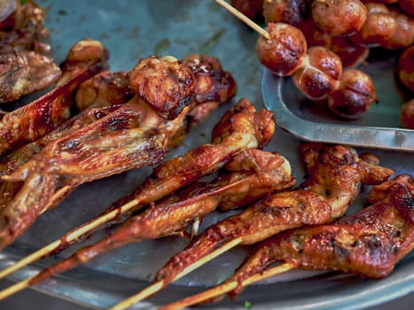 Thai street food in market. Isaan sausages. and Chicken grill on the stove