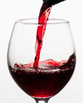 red wine pouring into glass on white background, AI generated