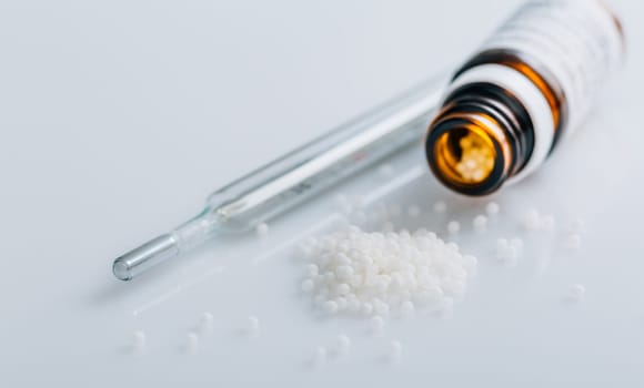 Homeopathic globules in small bottle, homeopathy concept