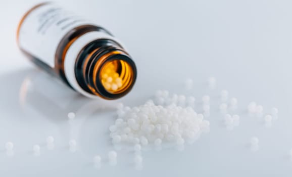 Homeopathic globules in small bottle, homeopathy concept
