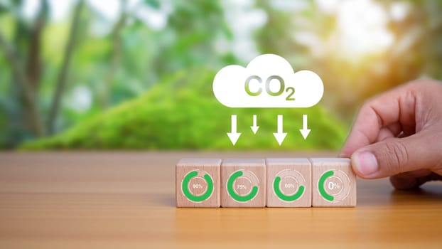 Human hands select zero carbon wooden blocks. It represents the concept of reducing CO2 emissions,Planting trees to reduce CO2 emissions, Environmental protection concept.
