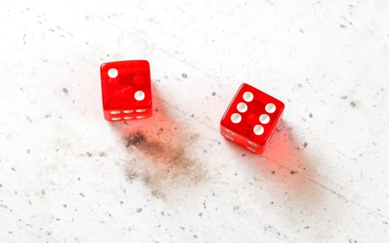 Two red craps dices showing Easy Eight (number 2 and 6) overhead shot on white board