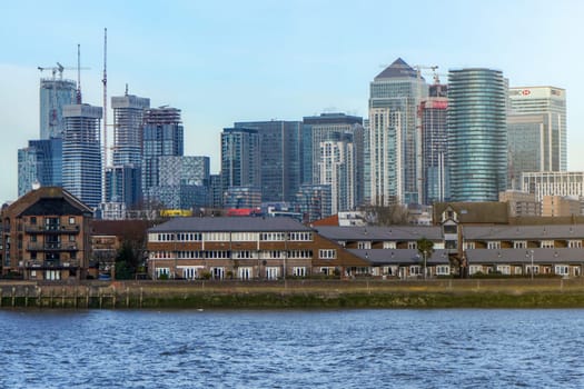 London, United Kingdom - February 03, 2019: View over river Thames on Canary Wharf, major financial district, with residential buildings in foreground.