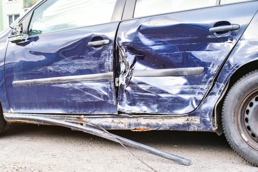 Crashed car, detail on side - metal plates deformed after accident hit.