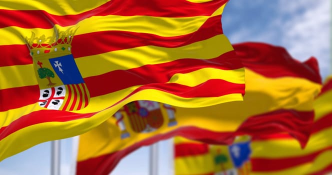 Aragon flag and Spanish flag waving in the wind. Aragon is an autonomous community in northeastern Spain. Selective focus. 3d illustration render. Close-up. Rippling fabric