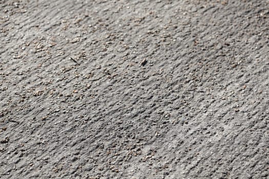 Gray asphalt, road surface with stones, Germany