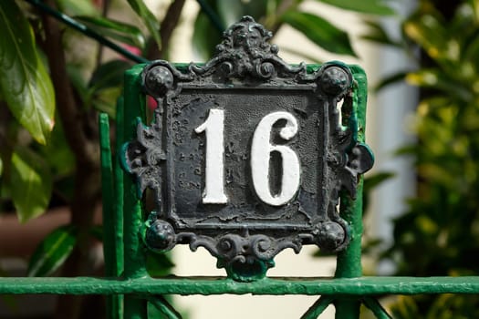 Old house number sign number sixteen and decorated metal garden fence, Ostertorviertel , Bremen, Germany