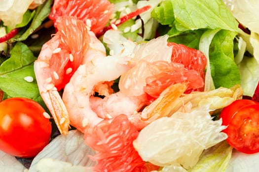 Diet salad with pomelo, shrimps and greens on a dark background. Healthy eating.