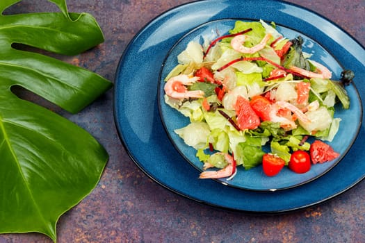 Diet salad with pomelo, shrimps and greens on a dark background. Healthy eating.