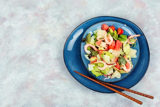 Diet salad with pomelo, shrimps and greens on a dark background. Healthy eating.