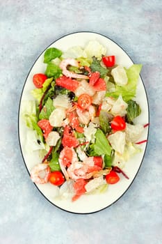 Diet salad with pomelo, shrimps and greens on a dark background. Healthy eating.