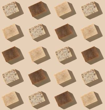 Patern with natural herbal beige and brown soap bars on light beige top view, hard shadows. Hygiene products for Spa and skin care. Organic handmade soap