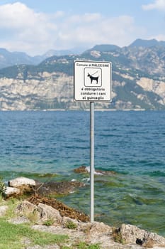 Sign on the shore of Lake Grada near Malcesine in Italy. Translation: Dogs must be kept on a lead