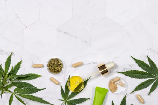 Cosmetics, CBD oil, hemp powder capsules, dry tea and green cannabis sativa leaves on a marble table top view, Mockup, Copy space. Organic skincare beauty products.