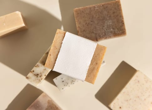 Beige and brown soap bars on light beige top view, hard shadows, packaging mockup, copy space. Natural herbal products for face and body care. Organic handmade skincare products