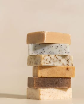 Tower stack of beige handmade soap bars on light beige close up. Natural hygiene products for body and skin care, minimal pastel composition