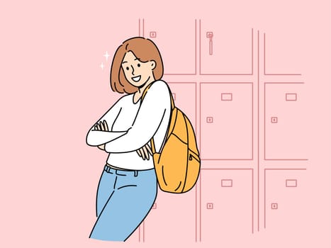 Woman student stands near boxes for personal items in college hallway and looks at screen smiling. Girl student at university or high school rejoices at opportunity to receive quality education.