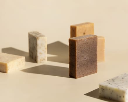 Natural herbal beige and brown soap bars on light beige close up, hard shadows. Hygiene products for Spa and skin care. Using organic handmade sopas in everyday routine