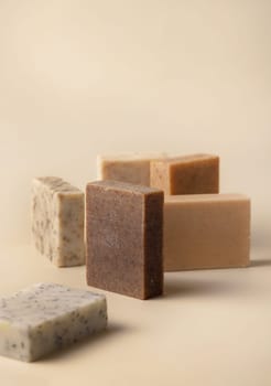 Natural herbal beige and brown soap bars on light beige close up, copy space. Hygiene products for Spa and skin care. Using organic handmade soaps in everyday bath routine