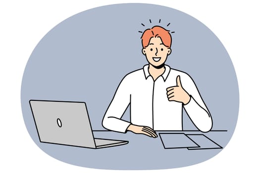 Smiling man at office desk show thumb up