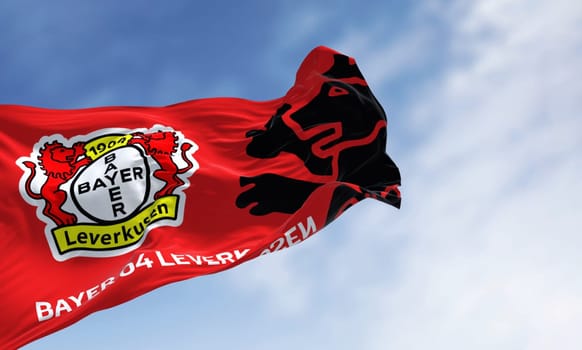 Leverkusen, DE, Nov. 2 2023: Bayer Leverkusen flag waving in the wind on a clear day. illustrative editorial 3d illustration render. Fluttering fabric. German Bundesliga Football club