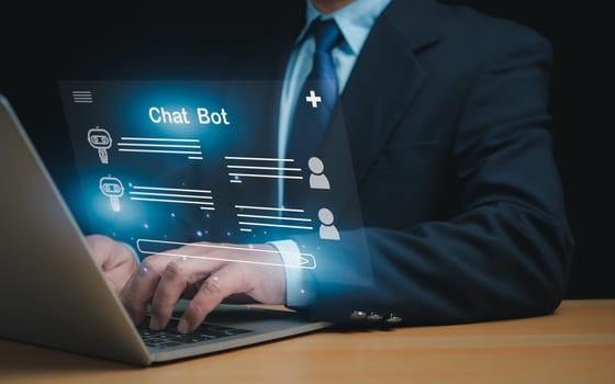 Businessman uses computer to type chat Ask and answer with the artificial intelligence system, chatbot, AI assistant.