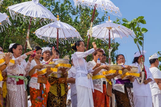 Bali, Indonesia: 17 August 2020: People during Melasti Ritual. Ceremony is held on the edge of the beach with the aim to purify oneself of all the bad things in the past and throw it to ocean.