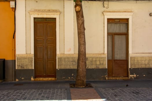 Old wooden door on a house with a tree on the Canary Island of Gran Canaria in Spain