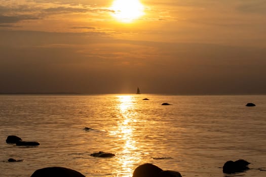 Beautiful orange sunset over the sea, a ship on the horizon