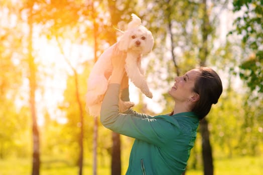 Young girl with her dog. Puppy white dog is running with it's owner. Conception about friendship, animal and freedom.
