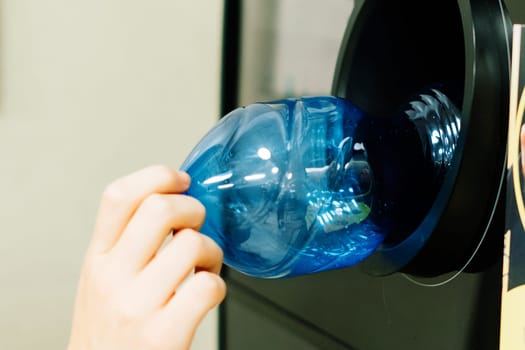 Reverse vending recycling machine that dispenses cash. Man hand puts plastic bottle to machine