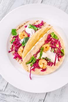 Tacos with shrimp, red cabbage, guacamole and sour cream