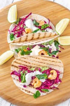 Tacos with shrimp, red cabbage, guacamole and sour cream