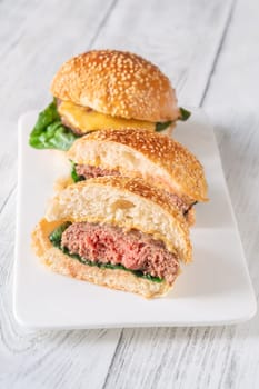 Two homemade cheeseburges on the wooden background