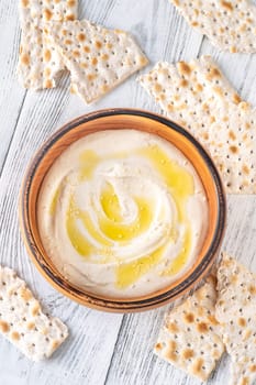 Wooden bowl of hummus on the white background