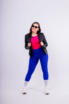 Strong female shows her biceps fashionable sportswear studio background. Strength and motivation