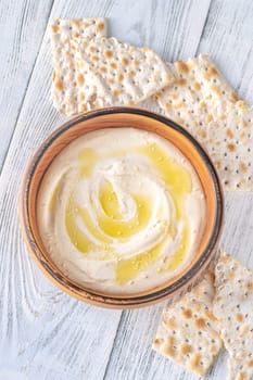 Wooden bowl of hummus on the white background