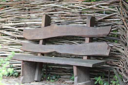 A wooden bench in front of  a timber wall
