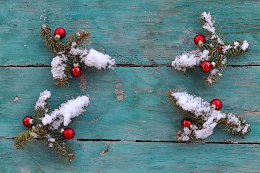 Christmas background Fir branches with Christmas tree baubles and snow on wood