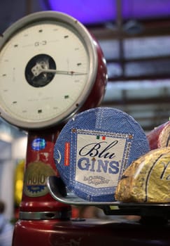 Cracow, Poland - November 17, 2022: Whole wheels of blue mold cheeses on an old shop scale at Enoexpo and Gastrofood - Trade Fair for Food and Drinks for Catering