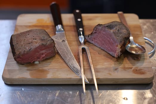 Grilled beef tenderloin on a wooden kitchen board, ready to eat