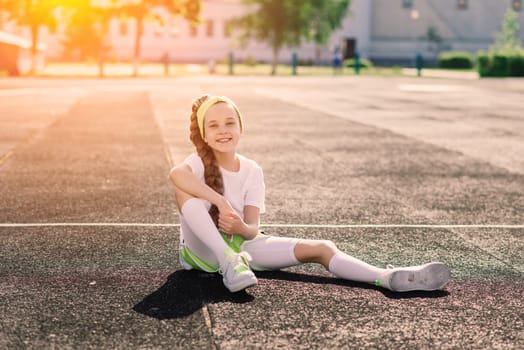 Girl jogging on a sunny summer evening, laying on treadmill, stadium, physical training, back to school, tired.