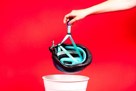 Photo of bike and engineer helmet in plastic trash bin, studio shot