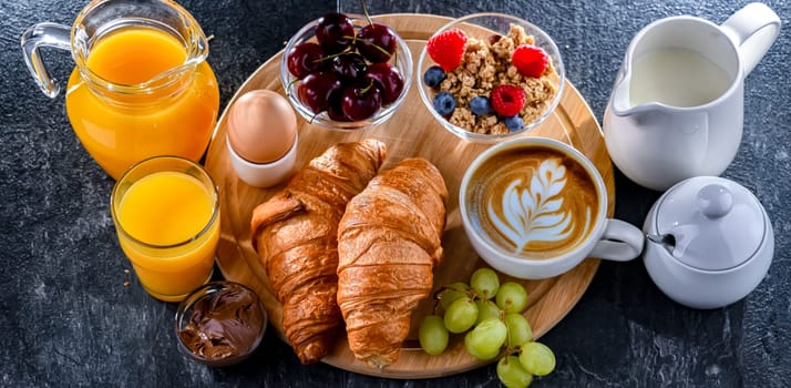 Breakfast served with coffee, orange juice, egg, cereals and croissants.