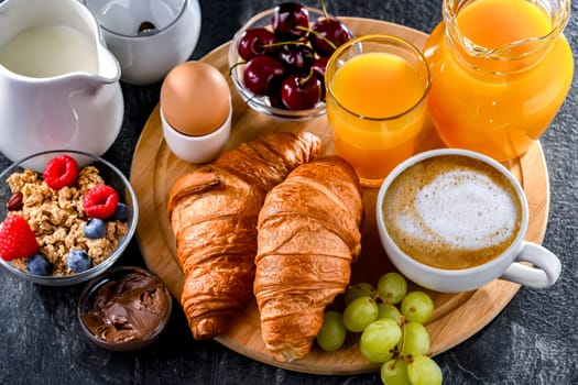 Breakfast served with coffee, orange juice, egg, cereals and croissants.