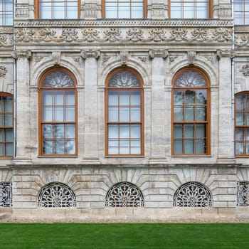 Side wall at Dolmabahce Palace, with three arched sash windows. Palace located in Besiktas district on the European coast of the Bosporus, Istanbul, Turkey