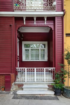 Charming wooden red house entrance with a white gate, stairs and wrought iron window, at Kuzguncuk neighborhood, Uskudar district, Istanbul, Turkey