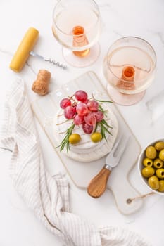 Cheese platter with French Camembert and Skyr cheese with grapes, olives and rose wine