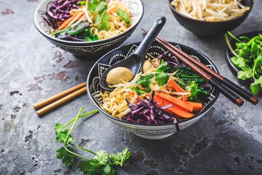 Vegan miso noodle soup with mushrooms, red cabbage, carrots and sprouts
